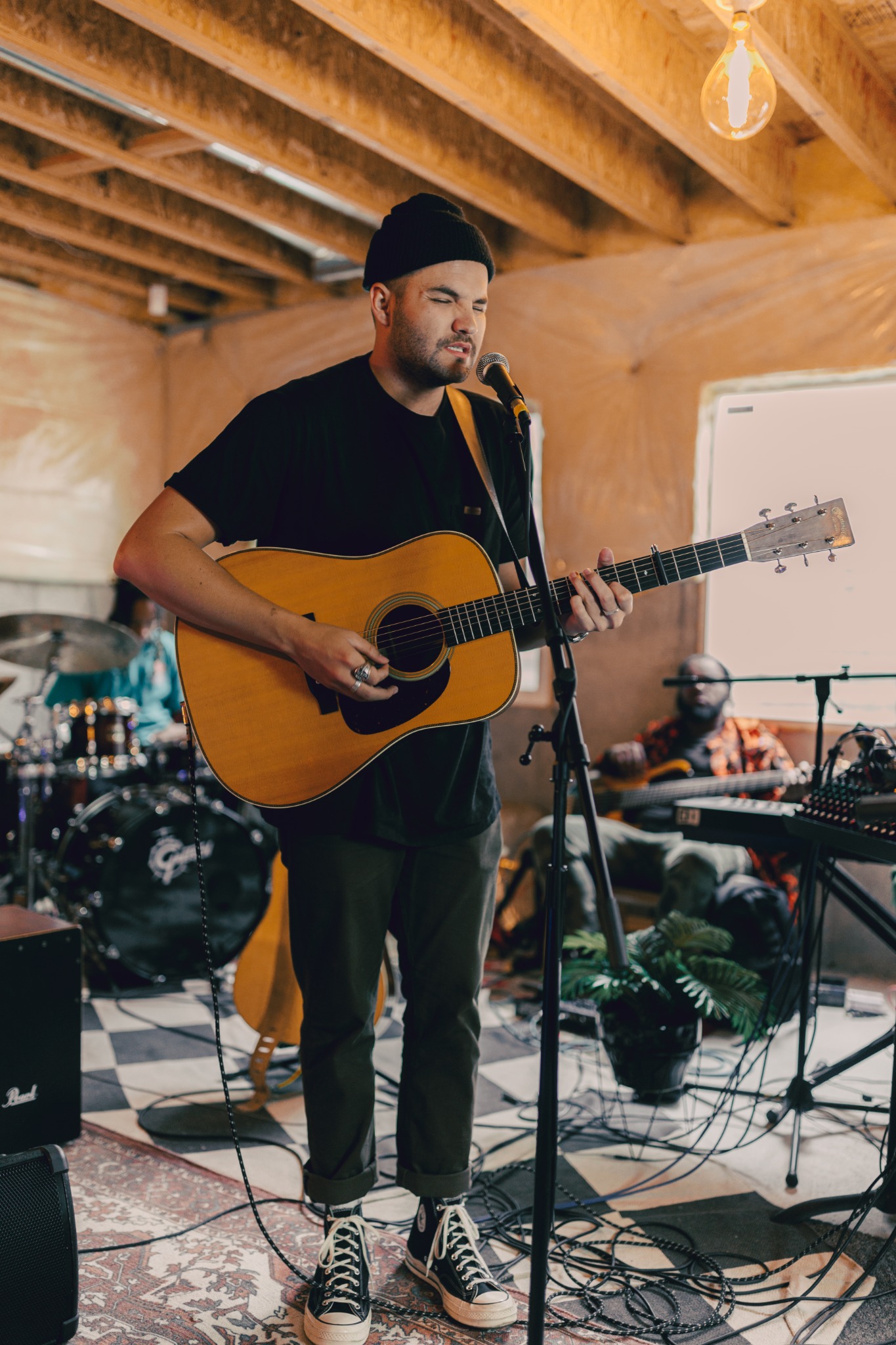 a singer playing acoustic guitar with the band
